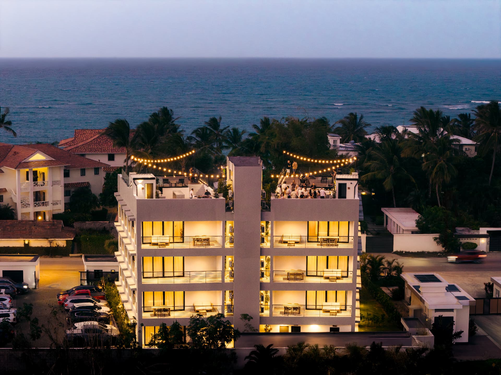 The Loop Hotel at dusk, with the lit rooftop terrace and the ocean behind